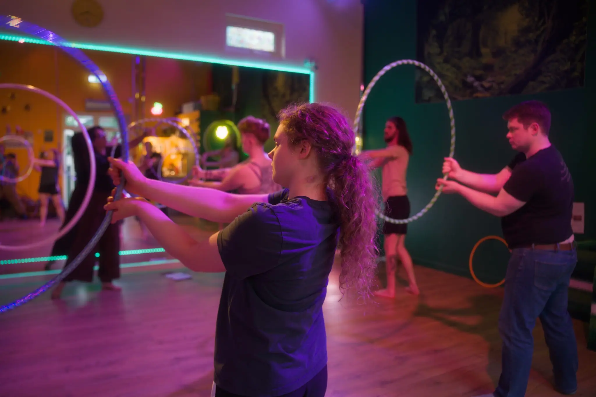 Student passing a pair of handmade hoops during a Flowsha workshop