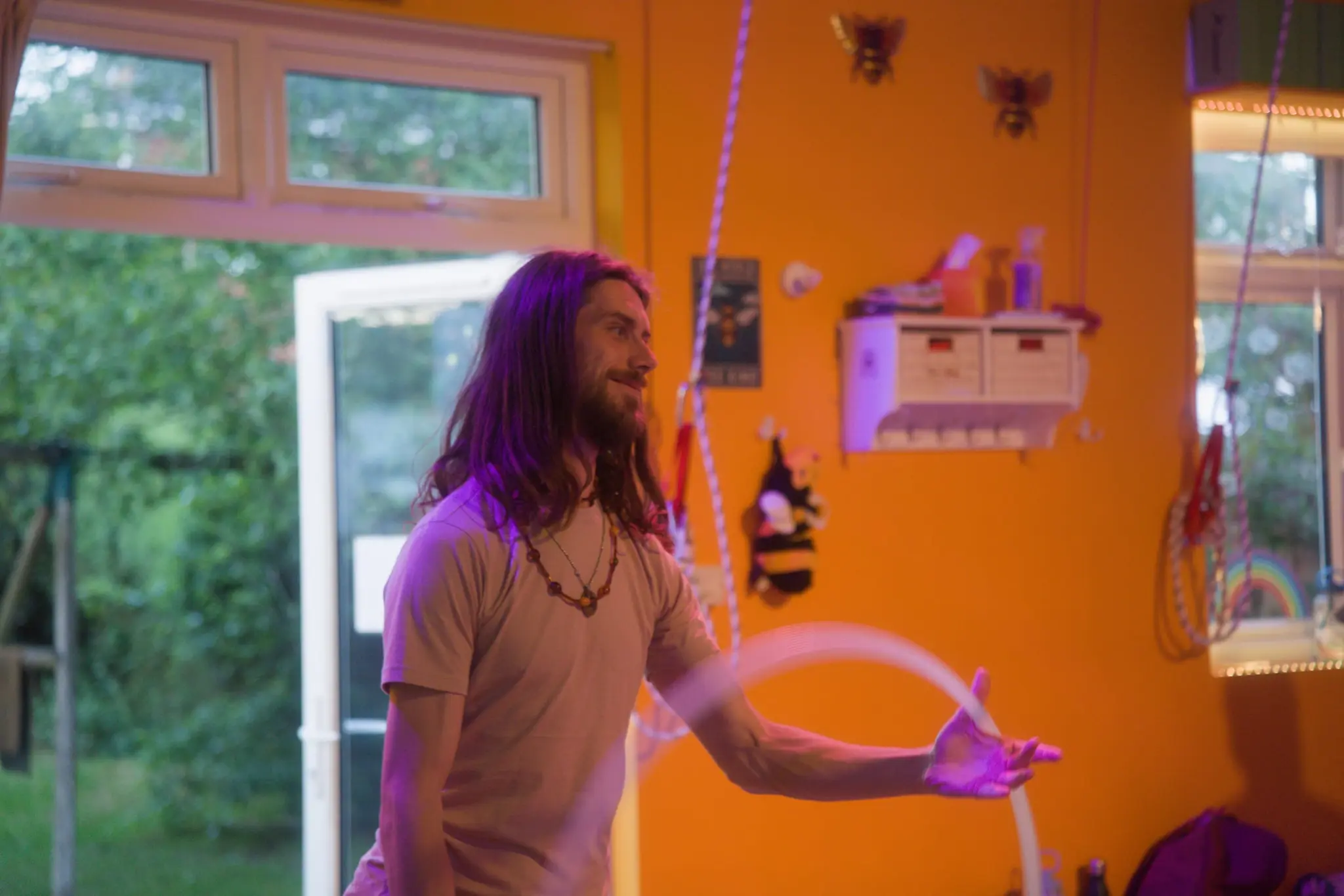 Hooper smiling as he plays with a hoop in a warm, sunlit room