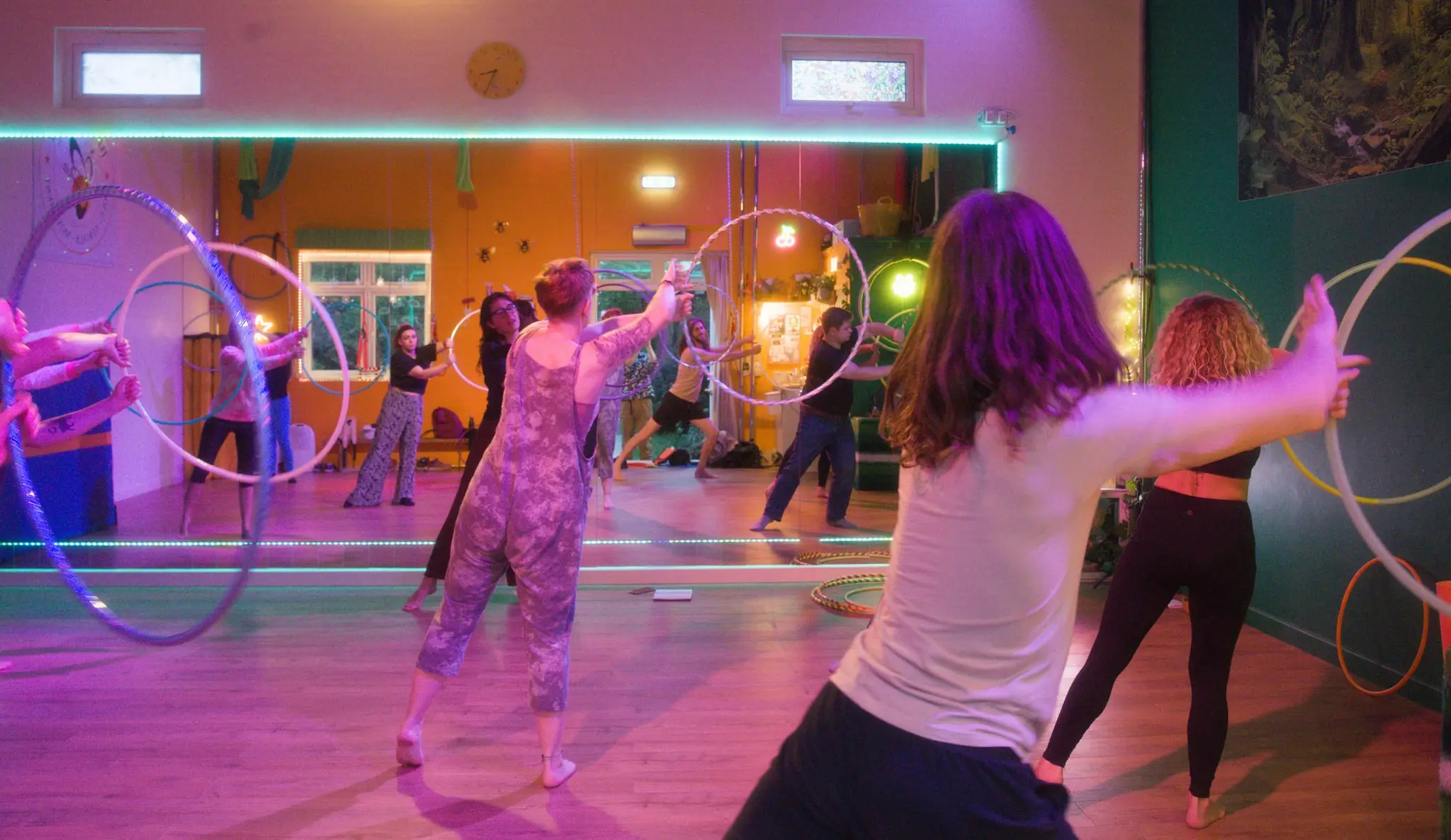 Group of hoopers raising their hoops overhead in a relaxed evening class