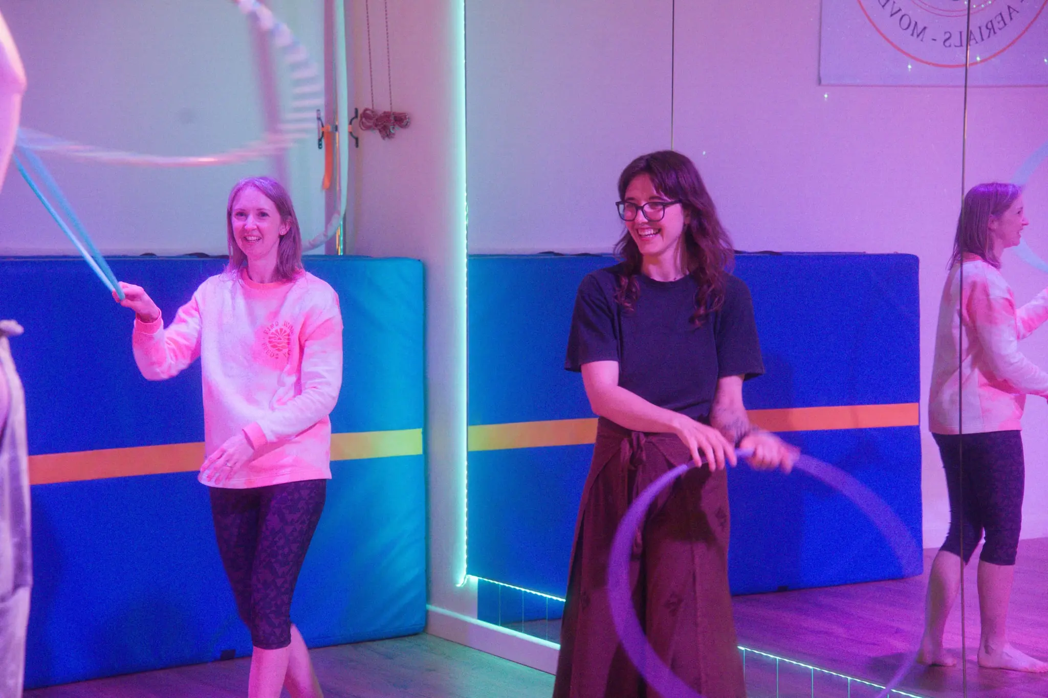 Osha smiling with a student during a hands-on hula hoop session
