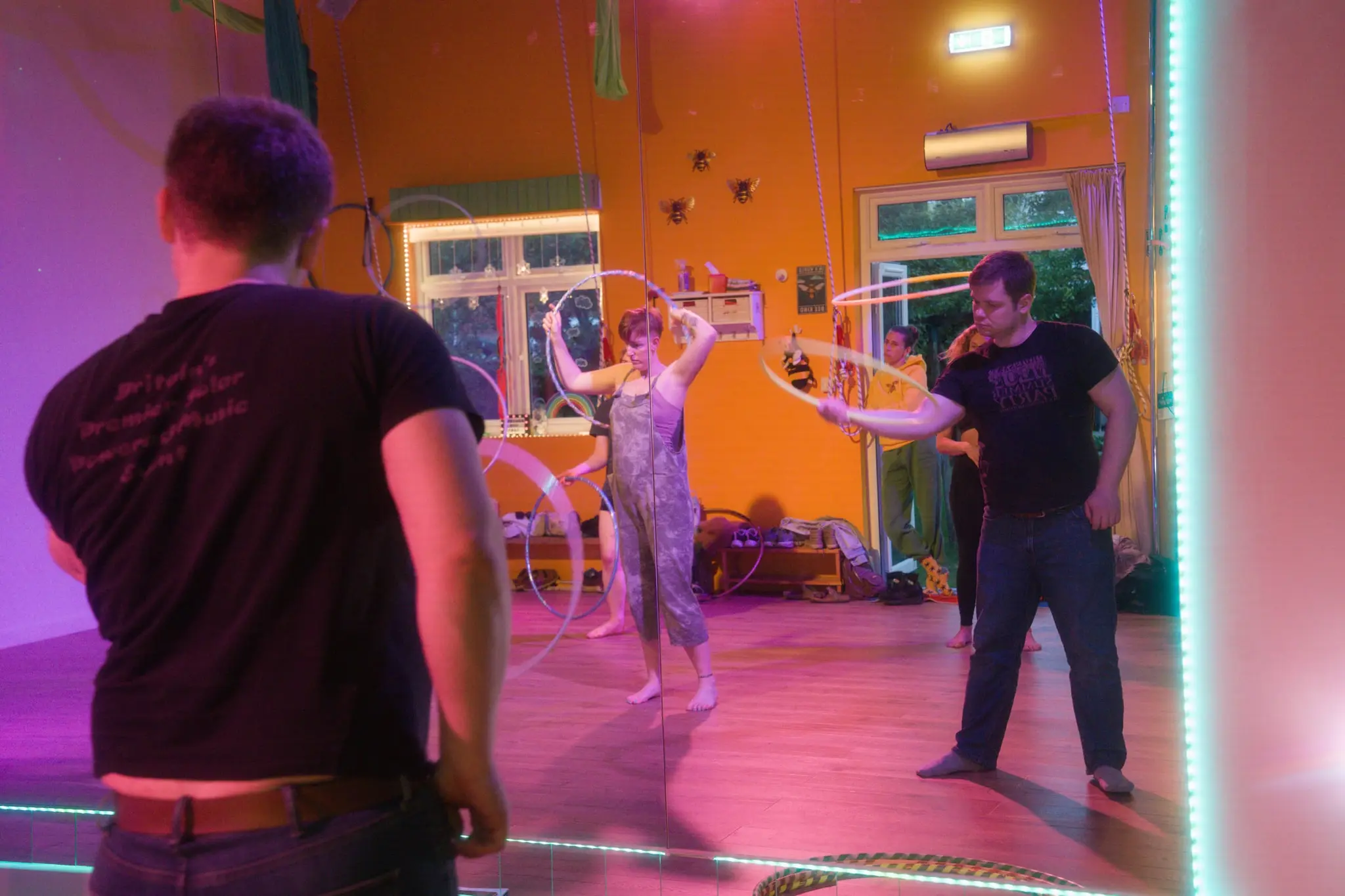Hoopers exploring movement together in a colourfully lit studio